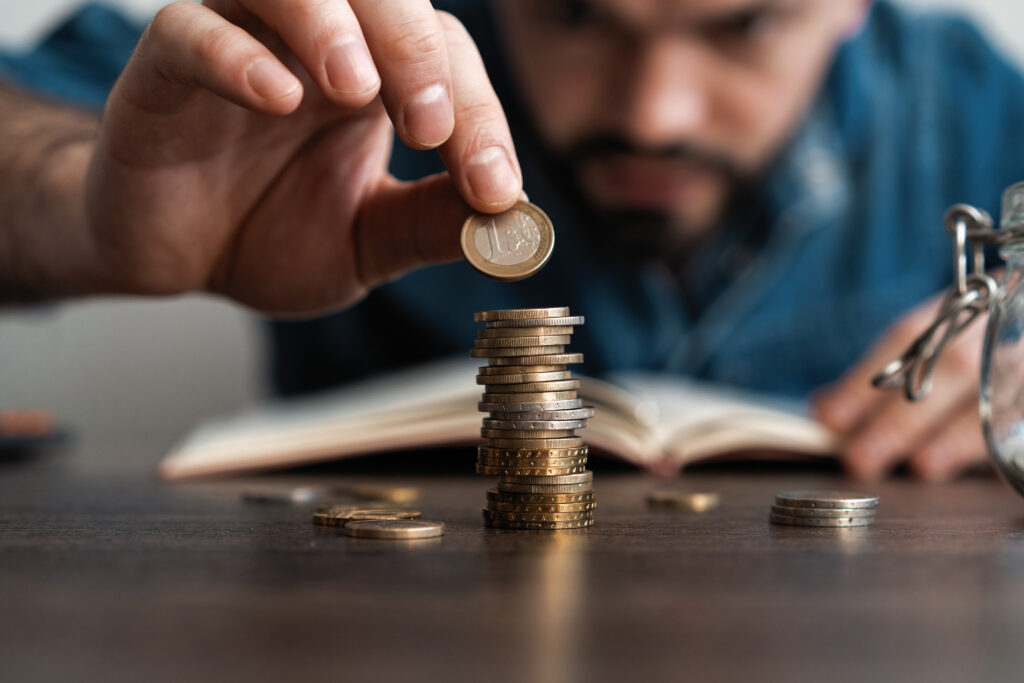 Business man putting a coin on coins stack saving bank and account for his money all in finance accounting concept