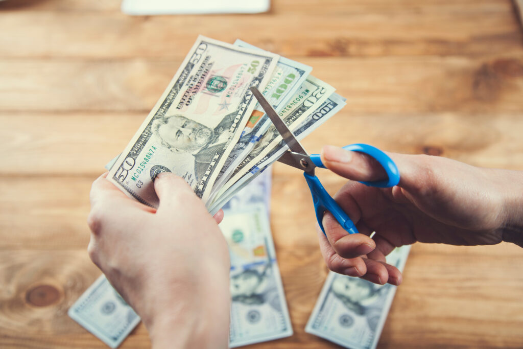 the woman cuts the money on table