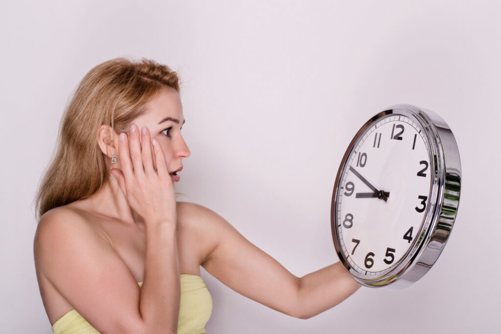 young beautiful woman holding big clock. time concept