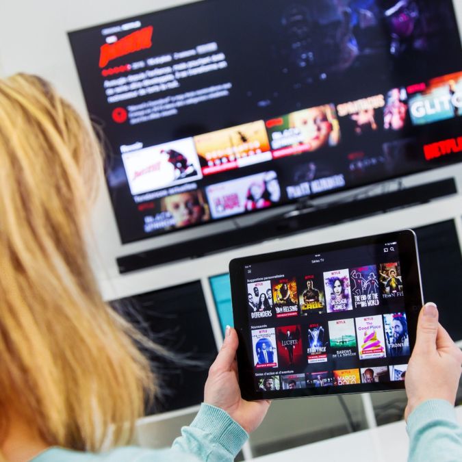 a woman watching on two devices