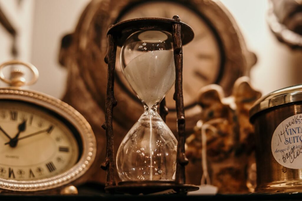 gold and brown pocket watch and hourglass