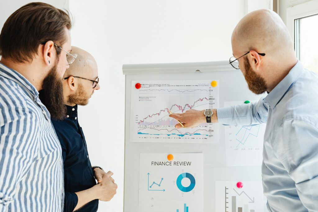 three men discussing a finance report