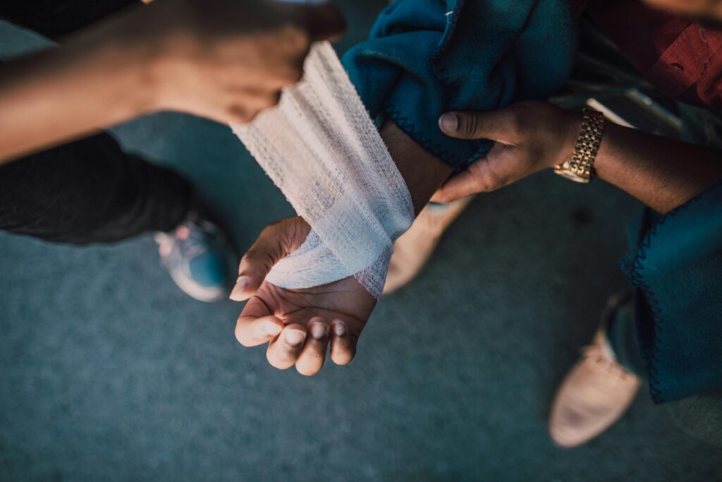 person wrapping another's wrist with a bandage