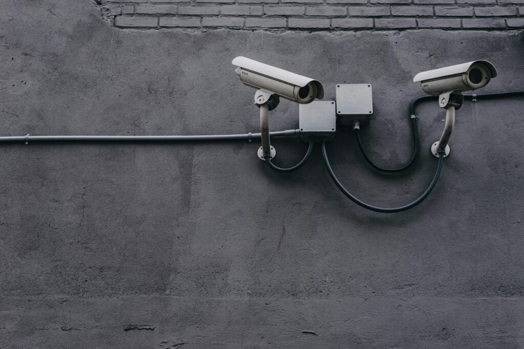 two security cameras on grey wall