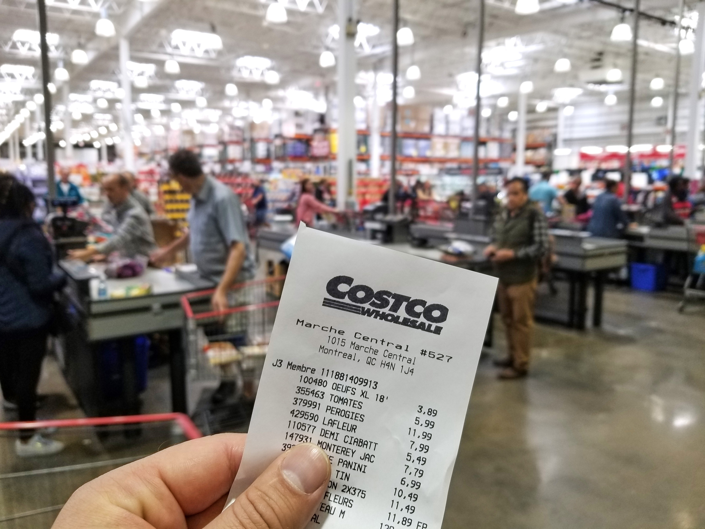 MONTREAL, CANADA - OCTOBER 5, 2018: A hand holding a receipt with the brand name and logo in Costco warehouse. Costco is an American corporation which operates a chain of membership only warehouses.
