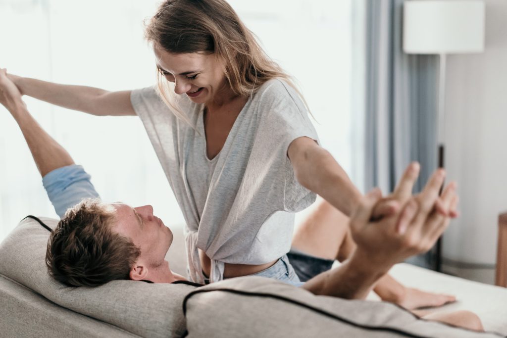 Affectionate couple lying on a couch looking at each other. loving romance