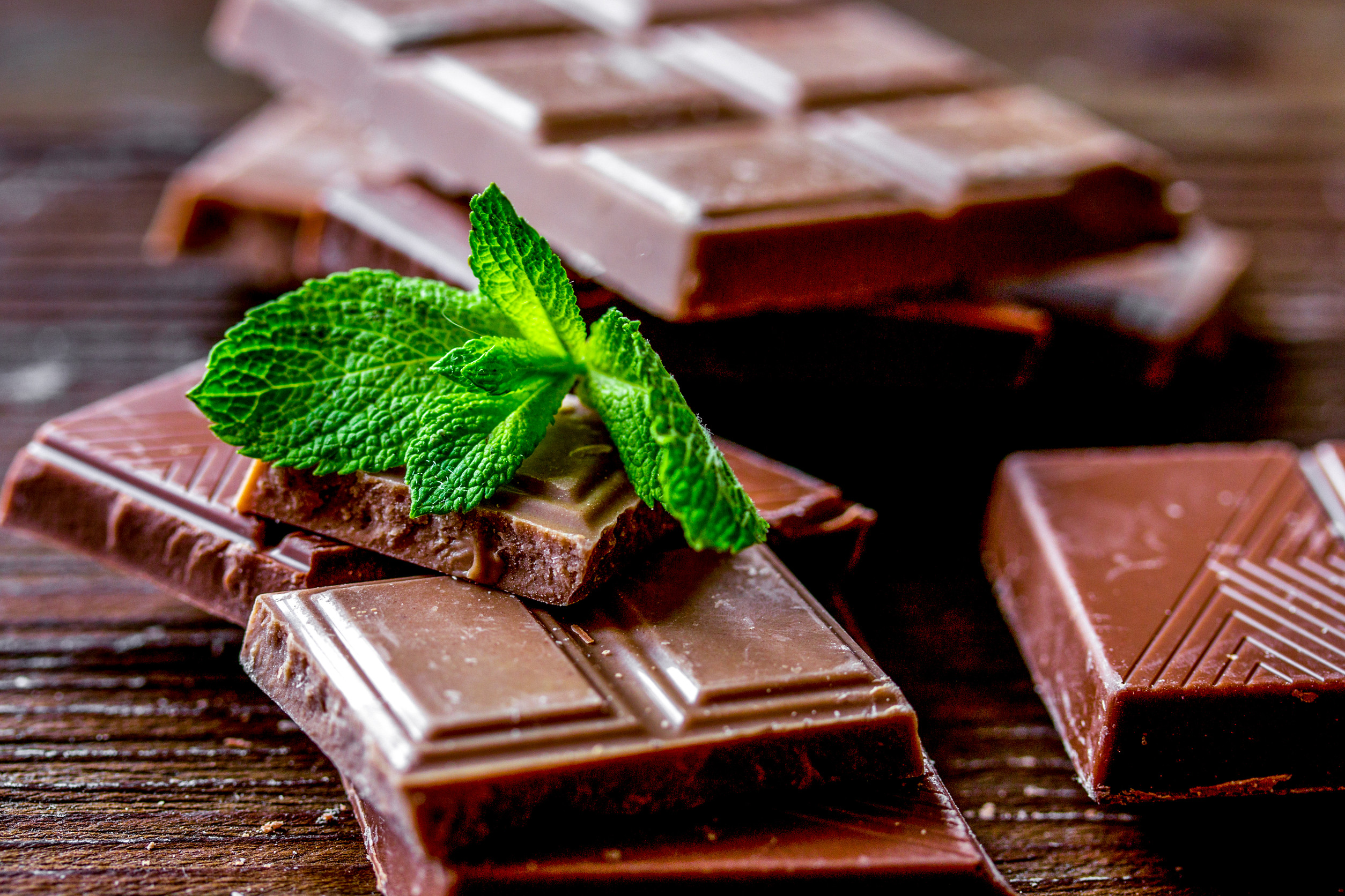 black and milk chocolate bars on dark wooden table background