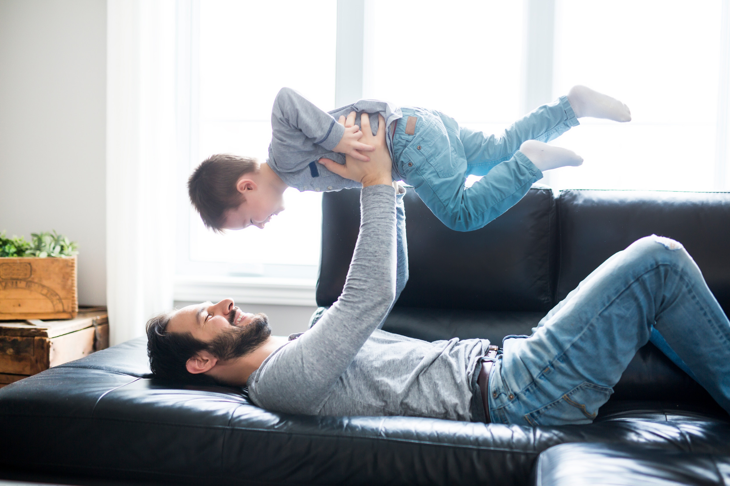 A Father And Children On Sofa At Home Watching TV Together