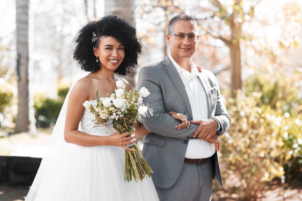 Portrait of a happy young bride getting walk down the aisle by her father on her wedding day