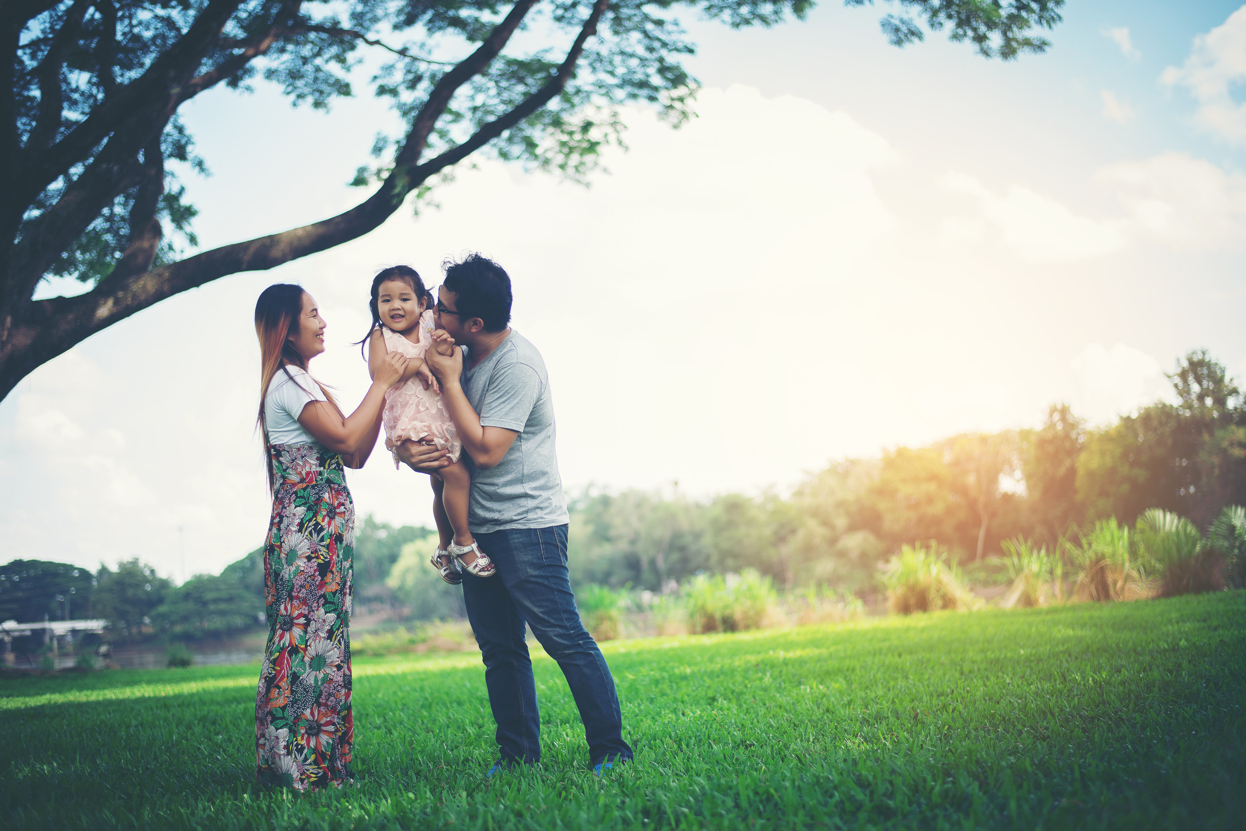 Happy family in the park, Father and Mother playing with daughter, relax family time