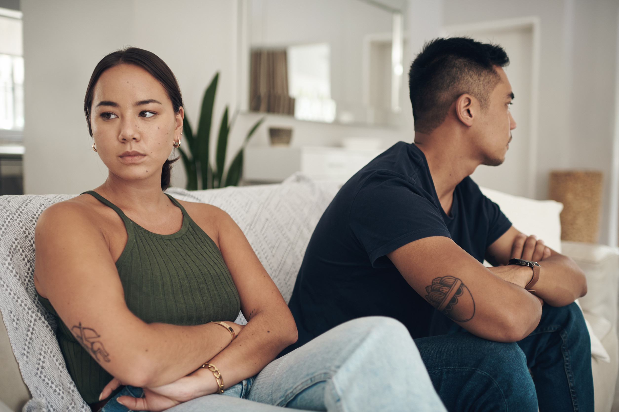 Sitting in silence. a young couple ignoring each other after an argument at home